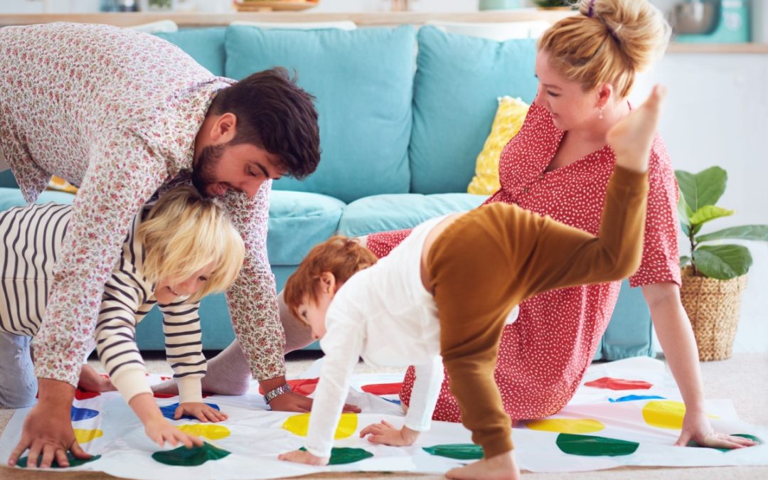 A family with young children playing Twister.