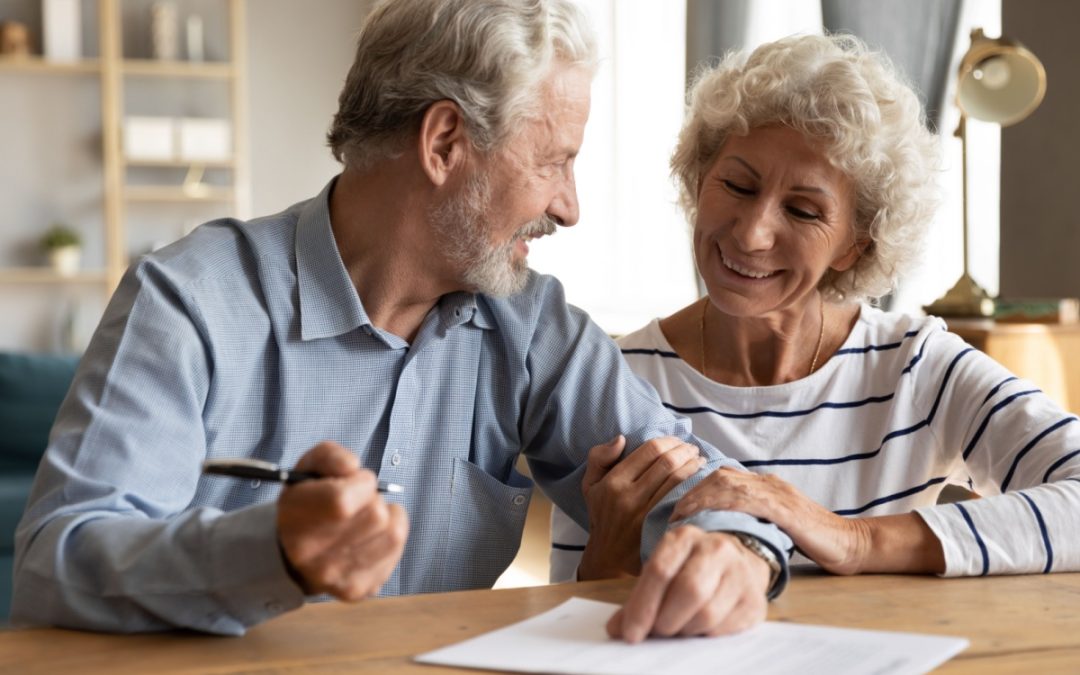 An older couple signing a document together