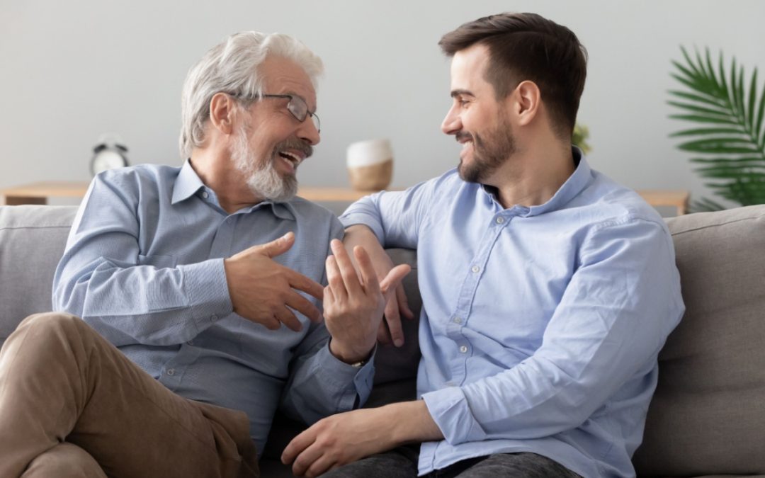 A father and adult son talking together.