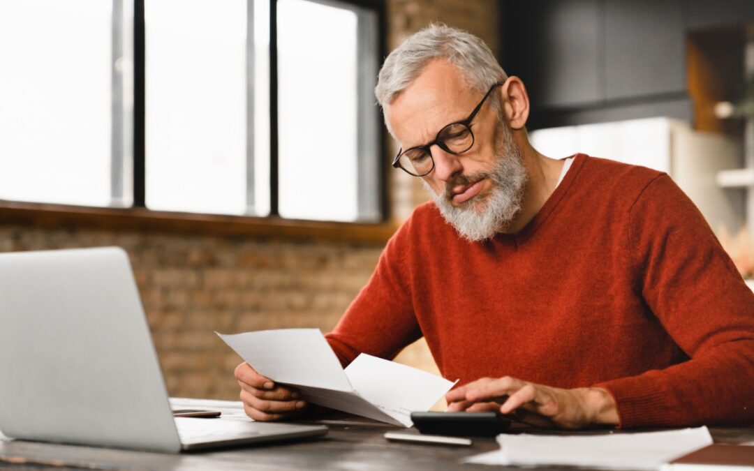 A man sitting at a computer and making calculations.