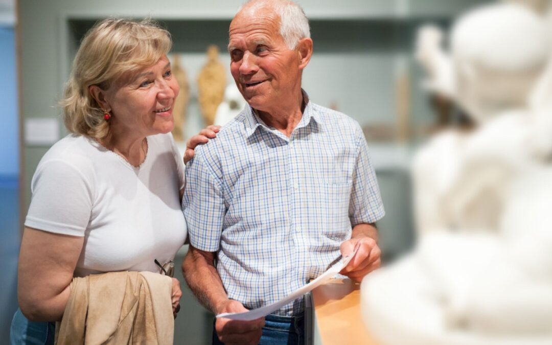 A couple looking at a statue in a museum.