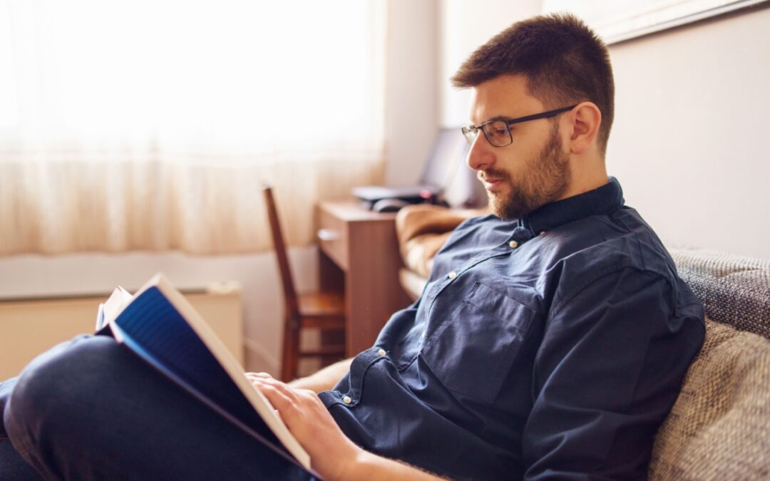 A man reading a book in his home.